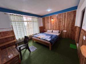 a bedroom with a bed and a chair in it at Highpeak Hideway Homestay in Lava +15 photos