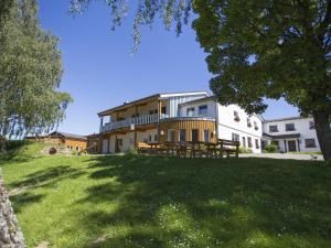 a large building on a hill with a green field at Hardthof Sauerland in Schmallenberg