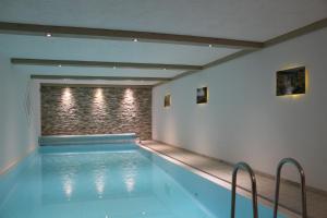 a swimming pool in a room with a brick wall at Hardthof Sauerland in Schmallenberg
