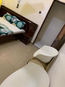 a room with a bed and a toilet and a mirror at Hôtel Okpèyèmi in Porto-Novo +7 photos