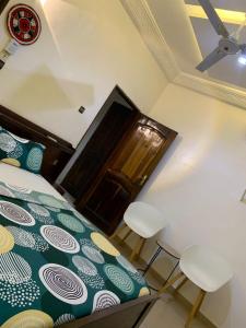a bedroom with a bed and two chairs and a door at Hôtel Okpèyèmi in Porto-Novo