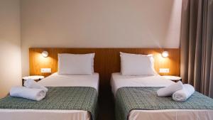 two beds in a hotel room with white pillows on them at Cosmos Residences in Vasiliki +15 photos