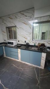 a kitchen with a marble counter top with a microwave at Hotel Majestic in Pelotas