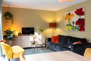 a living room with a couch and a tv at Vakantiehuis Vliegend Hert Veluwe in Nunspeet