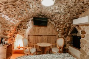 a room with a table and chairs in a stone wall at Kasr-ı Kikan Hotel in Mardin
