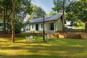 a house with tables and chairs in the yard at Serendib Signature Resort in Digana