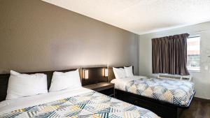 a hotel room with two beds and a window at Motel 6-Wethersfield, CT - Hartford in Wethersfield