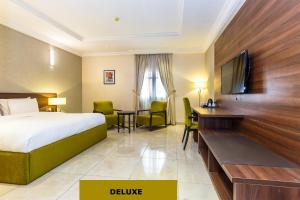 a hotel room with a bed and a desk at Joygate Hotels & Suites in Lagos