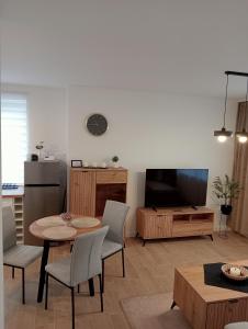 a living room with a table and chairs and a television at Apartament 42 in Sosnowiec