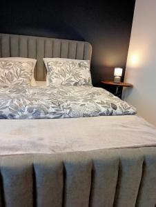 a bed with white sheets and pillows on it at Apartament 42 in Sosnowiec