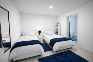 two beds in a white room with a mirror at Casa Silva Diamond in Pinhal Novo +17 photos