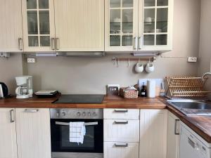 a kitchen with white cabinets and a stove top oven at FOS Ionian Breeze Studio in Platithriás