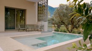 a house with a swimming pool with a table and chairs at Cosmos Residences in Vasiliki