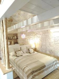a large bed in a room with a stone wall at Casa De Amicis 24 in Sammichele di Bari