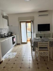 a kitchen with a table and chairs and a television at Lucys Home Giardini Naxos in Giardini Naxos