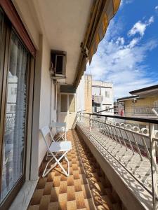 a white chair sitting on the balcony of a building at Lucys Home Giardini Naxos in Giardini Naxos