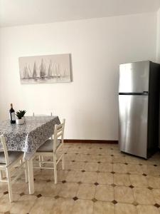 a dining room with a table and a refrigerator at Lucys Home Giardini Naxos in Giardini Naxos