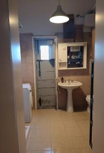 a bathroom with a sink and a toilet and a door at B&B Antica Neviera in Gioia del Colle