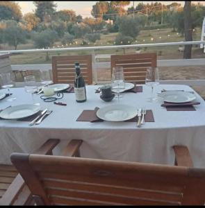 a table with a bottle of wine and glasses on it at B&B Antica Neviera in Gioia del Colle