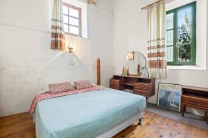 a bedroom with a bed and a desk and a mirror at Antonys Garden House in Episkopi Limassol