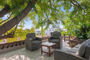 a patio with chairs and a table and trees at Antonys Garden House in Episkopi Limassol