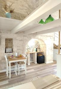 a kitchen with a table and chairs and a stone wall at Casa De Amicis 24 in Sammichele di Bari