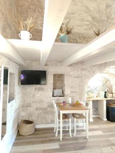 a dining room with a table and a stone wall at Casa De Amicis 24 in Sammichele di Bari
