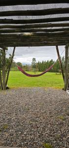 a hammock hanging from a wooden bench in a field at Chacra Dosvistas in Maldonado