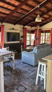 a living room with a couch and a television at Chacra Dosvistas in Maldonado