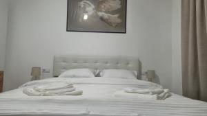 a bedroom with a white bed with towels on it at Zanora apartment's in Aiud