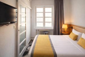 a hotel room with a bed and a window at The Originals Boutique, Hôtel Auberge du Forgeron, Lille Sud in Seclin +65 photos