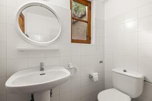 a white bathroom with a sink and a mirror at Antonys Garden House in Episkopi Limassol
