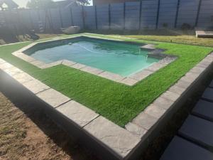 a swimming pool with grass around it at Silva Dolphin in Vredenburg