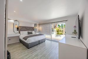 a bedroom with a bed and a large window at Luxury Camps Bay Getaway in Cape Town +25 photos
