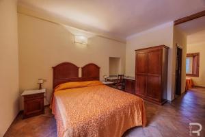 a bedroom with a bed with an orange bedspread at Albergo Miramonti in Comano