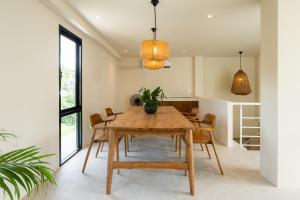 a dining room with a wooden table and chairs at ELYSIUM Villa Khao Lak in Khao Lak