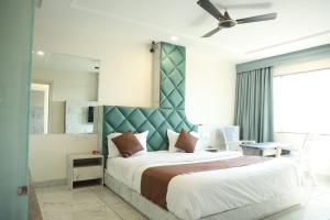 a bedroom with a large bed with a blue headboard at Hotel Magnet in Indore