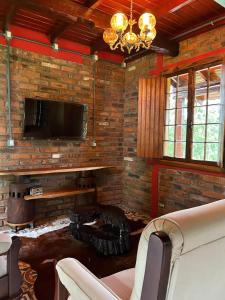 a living room with a fireplace and a flat screen tv at Chale do Morro in Marques de Sousa