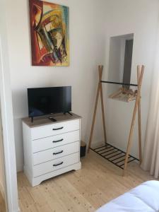 a bedroom with a white dresser with a tv on it at Villa plaisance in Plomodiern