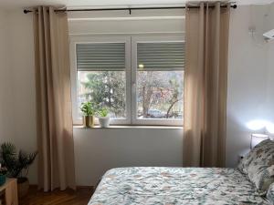 a bedroom with a window with curtains and a bed at Apartman Titi in Smederevo