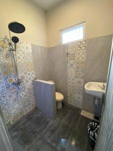 a bathroom with a toilet and a sink at Rasa Jogja Homestay in Yogyakarta