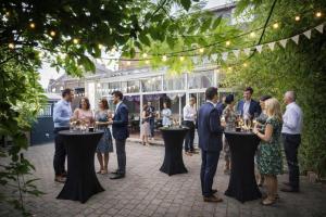 a group of people standing around tables with wine glasses at The Originals Boutique, Hôtel Auberge du Forgeron, Lille Sud in Seclin