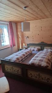 two beds in a bedroom with a wooden ceiling at Ferienhaus Schindeler in Mellau