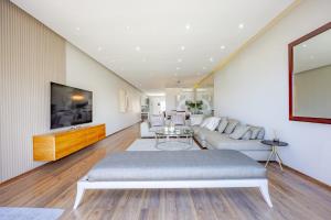 a living room with a couch and a tv at Luxury Camps Bay Getaway in Cape Town