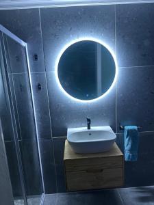 a bathroom with a sink and a round mirror at Silva Dolphin in Vredenburg +13 photos