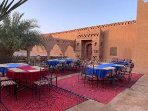 a courtyard with tables and chairs in a building at Auberge el oasis mharech in Foum Mharech +8 photos