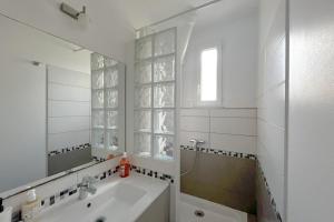 a white bathroom with a sink and a mirror at Room in elegant and charming 3-bedroom apartment near Bois de Vincennes in Paris +26 photos