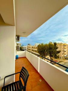 a balcony with a chair and a view of a city at Carisa rooms for holiday in Larnaca