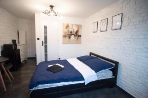 a bedroom with a bed and a white brick wall at Dream Loft in Kłodzko