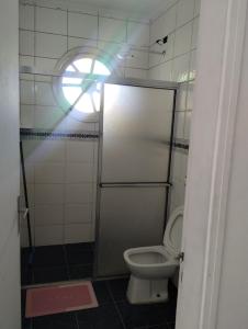 a bathroom with a toilet and a window at Novo Encanto in Ubatuba